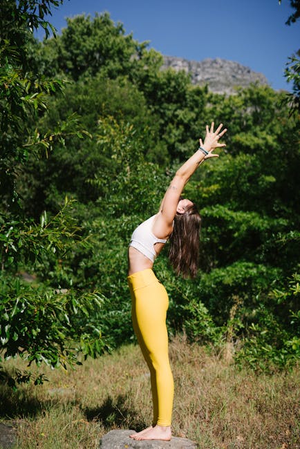 Woman practicing a peaceful yoga pose outdoors with nature background